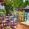 Outdoor restaurant with multicolored tables and chairs, Greece