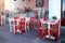 Outdoor restaurant with white table and red chairs, Crete, Greece.