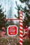 Outdoor road barrier in Christmas decorations in pine trees with the inscription Santa, please stop here.