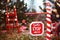 Outdoor road barrier in Christmas decorations in pine trees with the inscription Santa, please stop here.