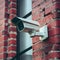 Outdoor security camera mounted on rustic red brick wall