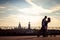 Outdoor shot of affectionate young couple pose against beautiful city view and sky, have rest after skateboading