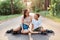 Outdoor shot of beautiful woman sitting on asphalt road with her son, wearing casual clothing and roller skates, family having