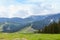 Outdoor shot of enchanting meadow with lot of green and trees, holiday resort around mountains situated at low lands, being