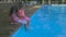 Outdoor shot of two little girls dipping their feet in the pool. Cute little girls sitting on the edge of a swimming