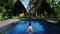 Outdoor shot of woman swimming in beautiful swimming pool jungles