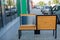 Outdoor shot of wooden bench in park having solar power panel installed, USB cabel connected to smartphone