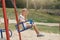 Outdoor shotof charming little girl on playground having fun at summer time,waiting for friend for playing, posing alone, cute