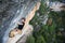 Outdoor sport activity. Rock climber ascending a challenging cliff. Extreme sport climbing.