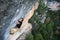 Outdoor sport. Rock climber ascending a challenging cliff. Extreme sport climbing.