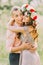 Outdoor spring portrait of young romantic hipster couple hugs posing, in the city garden around blooming trees and flowers