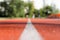 Outdoor stadium jogging track. Texture of red rubberized surface with a white line in the middle. Running track close-up.