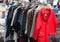 Outdoor stand on a flea market with used clothing and a red dres