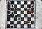 Outdoor stone chessboard with black and yellow figures top view. Competition and strategy concept. Defeat and fight concept.