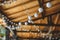 outdoor string lights hanging on a line with under a wooden roof.