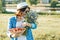 Outdoor summer portrait of adult woman with strawberries, bouquet of wildflowers, straw hat and sunglasses. Nature background,