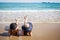 Outdoor summer portrait of the front image of two Asian beautiful girls in a sexy bikini lie down on the beach