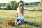 Outdoor summer portrait of little girl with basket strawberries, straw hat. Nature background, rural landscape, green meadow,