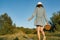 Outdoor summer portrait of teen girl with basket strawberries, straw hat. Girl on country road, back view. Nature background,