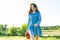 Outdoor summer portrait of teen girl with basket strawberries, straw hat. Nature background, rural landscape, green meadow, countr