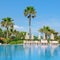 Outdoor swimming pool, palm trees and sunloungers