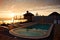 Outdoor swimming pool with sea view. Dawn on the sea. View from the mountain. Orange dawn.