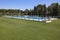 Outdoor swimming pool surrounded by grass. Recreation area. Copy space