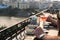 Outdoor table in a cafe and bar with an orange cocktail and man hands closeup. Urban cityscape and lake on background. Brilliant s