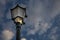 Outdoor Victorian Style Streetlight with Smoked Glass and Lighted Bulb. Upward View of Black Iron Cast Single Pillar