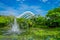 Outdoor view of a beautiful garden with an artificial lake with many Lily pads in the water and a fountain in the middle