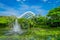 Outdoor view of a beautiful garden with an artificial lake with many Lily pads in the water and a fountain in the middle