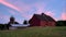 Outdoor view of a farmhouse under a scenic sunset in the countryside