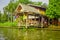 Outdoor view of floating poor house with two falgs at the enter of the building on the Chao Phraya river. Thailand