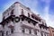 Outdoor view of huge white spanish colonial house with christmast adorn and wrought iron and plants located in dowtown