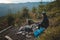 Outdoor wilderness trekking enthusiast sitting by a campfire enjoying breakfast at sunrise. Breakfast and catching vitamin D at