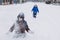 Outdoor winter activities for kids. Kids playing in the suburbs, winter backyard gathering. Boys having fun with snow