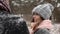 Outdoor winter forest shot of young wedding couple walking, smiling and speaking in snow weather pine forest during