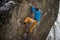 Outdoor winter sport. Rock climber ascending a challenging cliff. Extreme sport climbing.