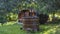 Outdoor wooden barrel sauna in the garden. In foreground wooden bathtub with fireplace. Wooden hot tub with spa in