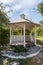 Outdoor wooden gazebo over summer landscape background.