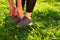 Outdoor workout. A woman ties her laces on her running shoes before jogging. View in the backlight of the setting sun. Close-up