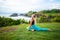 Outdoor yoga practice. Young woman practicing Ardha Kapotasana, Half Pigeon Pose. Chest opener improving breathing. Tanah Lot