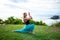 Outdoor yoga practice. Young woman practicing Ashwa Sanchalanasana, Equestrian or riding pose. Hands in namaste mudra. Bali,