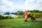 Outdoor yoga practice. Young woman practicing variation of Parvatasana, Mountain pose. Head touching ground. Hands up. Tanah Lot