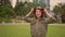 Outdoors 360 degree gimbal shot on young attractive and fit woman putting on hoodie starting running at green city park