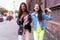 Outdoors fashion portrait young pretty best girls friends in friendly hug. Walking at the city.