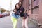 Outdoors fashion portrait young pretty best girls friends in friendly hug. Walking at the city.