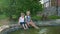 Outdoors games, barefoot children wet their feet while playing with water in a pond sitting together in park