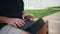 Outdoors hands typing keyboard closeup. Mature freelancer working tablet in park