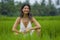 Outdoors holidays portrait of middle aged attractive and elegant Asian woman in white dress enjoying beauty of nature at tropical